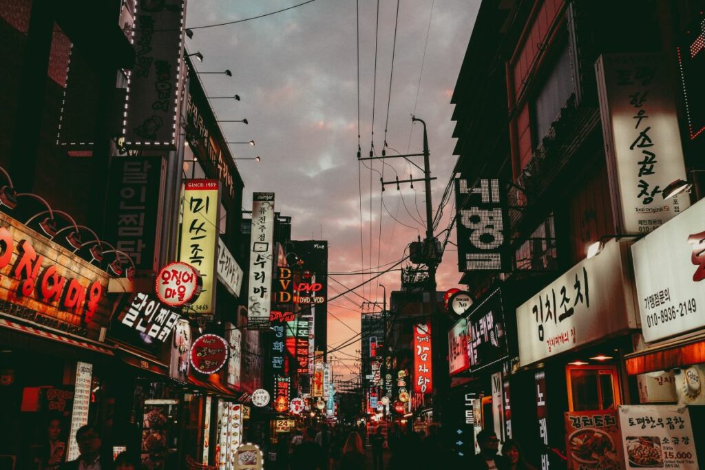 Sun setting in the background of a city street in Seoul, South Korea. Photo by Sava Bobov on Unpslash. 