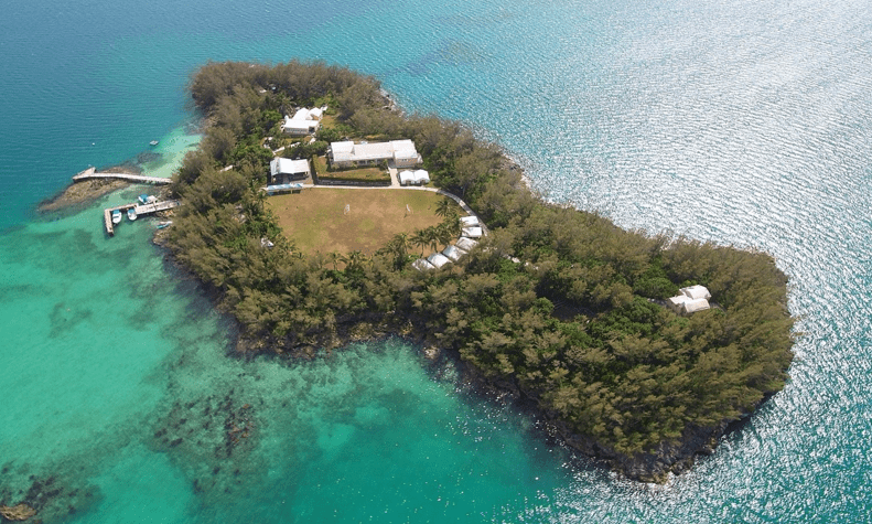 An ariel photo of a beautiful Island with trees, buildings, and coastal reefs. Photo by Word of Life Bermuda.